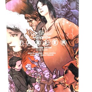 May include: The Deluxe Edition Book Three of Fables comic book series. The cover features a group of characters, including a woman with long black hair, a man with a beard, and a young boy. The background is a dark, shadowy scene with a lot of detail.