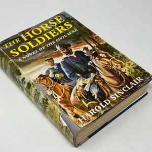 May include: A vintage paperback book titled "The Horse Soldiers" by Harold Sinclair. The cover features a painting of three soldiers on horseback during the Civil War.