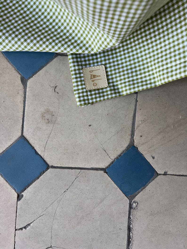 May include: A green and white gingham fabric with a brown leather label that says "BALLO" in white lettering.