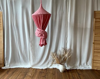 Dosel de muselina rosa fresa: decoración para cuna o sala de juegos.