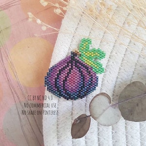Peut inclure: Un oignon violet perlé avec une feuille verte sur le dessus. L'oignon est fait de petites perles colorées et a un contour bleu foncé. La feuille est faite de perles vertes et jaunes.