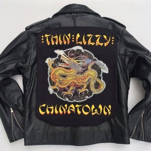 May include: Black leather jacket with a black patch featuring a yellow dragon and the text "Thin Lizzy: Chinatown".