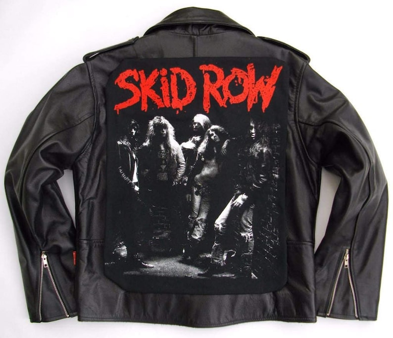 May include: Black leather jacket with a large black and white band patch on the back. The patch features a band of five people with the text "SKID ROW" in red letters.