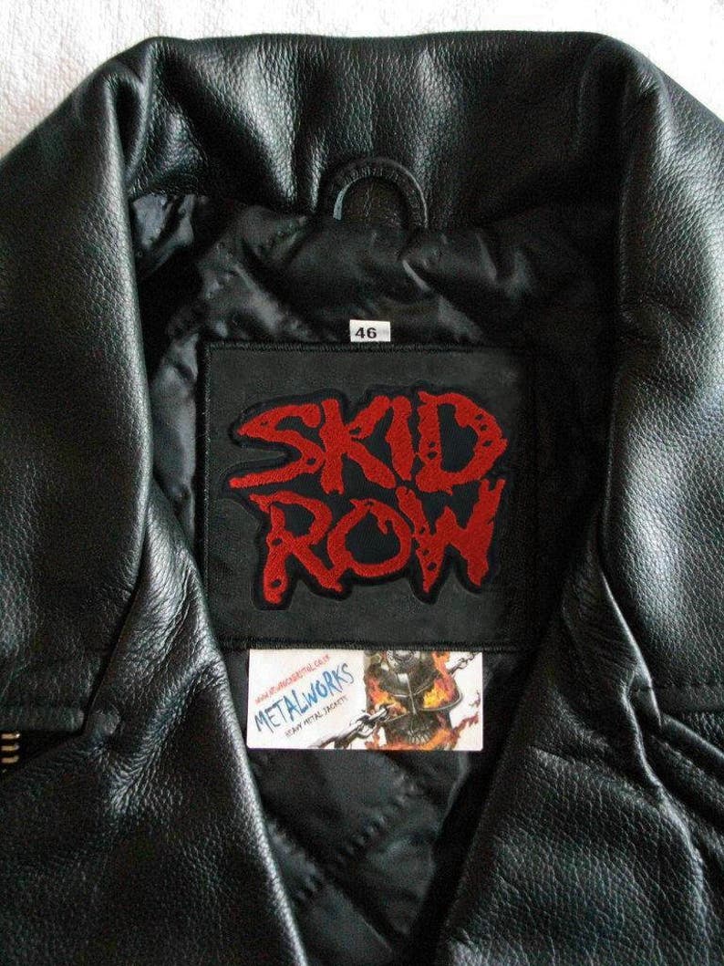 May include: Black leather jacket with a red "Skid Row" patch sewn on the inside of the collar. The patch is on a black background with white stitching. The jacket has a size tag that says "46".