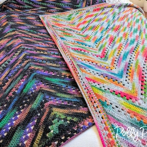 Può includere: Due coperte all'uncinetto, una con un motivo a chevron nero e multicolore e l'altra con un motivo a chevron grigio e multicolore. Le coperte sono disposte su una superficie bianca. Il testo "Polly Plum" è visibile nell'angolo in basso a destra dell'immagine.