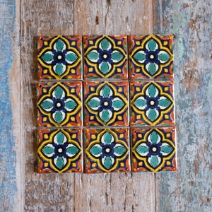 May include: Nine colourful ceramic tiles with a geometric pattern of blue, green, yellow and red. The tiles are arranged in a 3x3 grid.