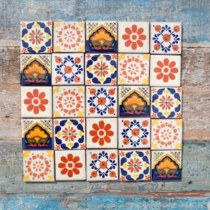 May include: A collection of square ceramic tiles with colourful floral and geometric designs. The tiles feature a variety of patterns in shades of orange, blue, yellow, and white. The tiles are arranged on a weathered wooden surface.