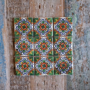 May include: Nine square ceramic tiles with a colourful geometric pattern. The tiles feature a repeating design of green, blue, orange, and white.