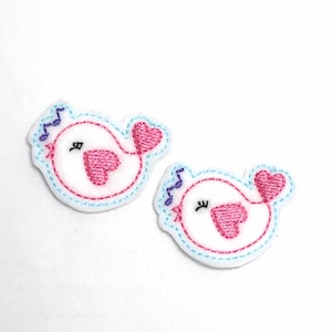 Puede incluir: Dos parches de fieltro blanco bordados con un diseño de pájaro. Cada pájaro tiene un corazón rosa y una nota musical, mejillas rosadas y ojos cerrados.