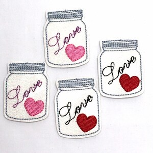 以下が含まれることがあります： 白いガラス瓶の形をした刺繍パッチが4つ。パッチには「Love」という文字が筆記体で書かれており、中には赤またはピンクのハートが入っています。