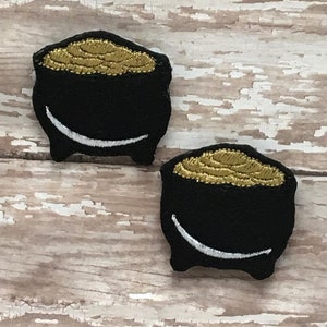 以下が含まれることがあります： 白い縁取りのある黒いフェルト製の金の壺のパッチが2つ。壺は金貨でいっぱいです。