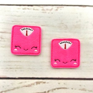 May include: Two pink felt scale patches with a happy face and a black and white scale design.