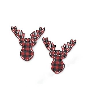 May include: Two red and black plaid reindeer head ornaments with white stitching.