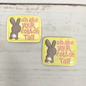 May include: Two yellow felt patches with a brown bunny and the text "shake your cotton tail" in pink embroidery.