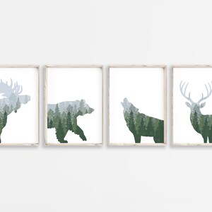 May include: Four framed art prints featuring forest animal silhouettes: a moose, bear, wolf, and deer. Each animal is filled with a green and gray forest scene. The prints have a white background and are in light wood frames.