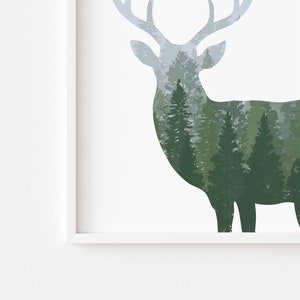 May include: A framed art print featuring a deer silhouette filled with a forest scene. The deer is in shades of gray and the forest is in shades of green. The artwork is set against a white background.