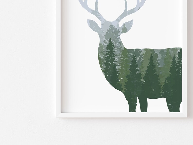 May include: A framed art print featuring a deer silhouette filled with a forest scene. The deer is in shades of gray and the forest is in shades of green. The artwork is set against a white background.