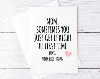 May include: A white card with black text that reads "Mom, sometimes you just get it right the first time. Love, Your First Born". A pink heart is next to the text "Your First Born".