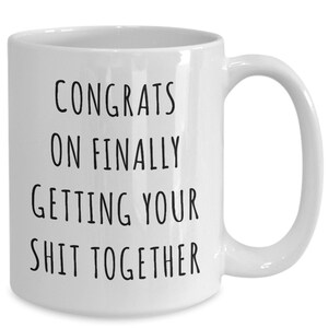 Puede incluir: Taza de caf&eacute; de cer&aacute;mica blanca con texto negro que dice "Felicidades por finalmente poner tu vida en orden".