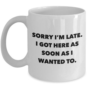 May include: White ceramic coffee mug with black text that reads "Sorry I'm late. I got here as soon as I wanted to."