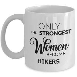 May include: White ceramic mug with a curved handle. The mug features the text "ONLY THE STRONGEST Women BECOME HIKERS" in black lettering. A perfect gift for hikers.