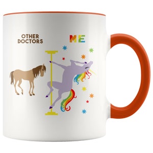 May include: White ceramic coffee mug with a red rim and handle. The mug features a graphic of a unicorn doing a pole dance with the text "ME" above it. A brown horse is on the left side of the mug with the text "OTHER DOCTORS" above it.