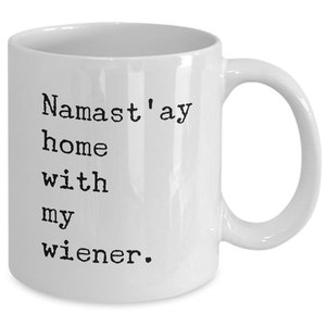 May include: White ceramic coffee mug with black text that reads "Namaste'ay home with my wiener."