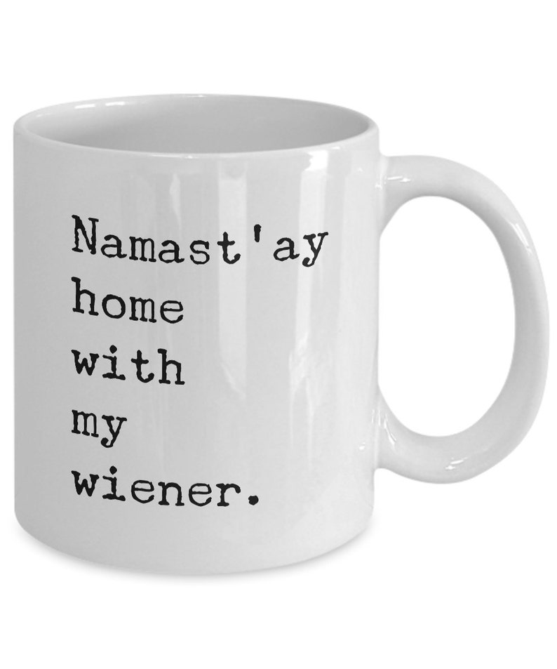 May include: White ceramic coffee mug with black text that reads "Namaste'ay home with my wiener."