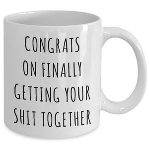 Puede incluir: Taza de caf&eacute; de cer&aacute;mica blanca con texto negro que dice "Felicidades por finalmente poner tu vida en orden".