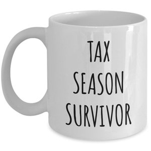 Puede incluir: Taza de caf&eacute; de cer&aacute;mica blanca con texto negro que dice "Tax Season Survivor".