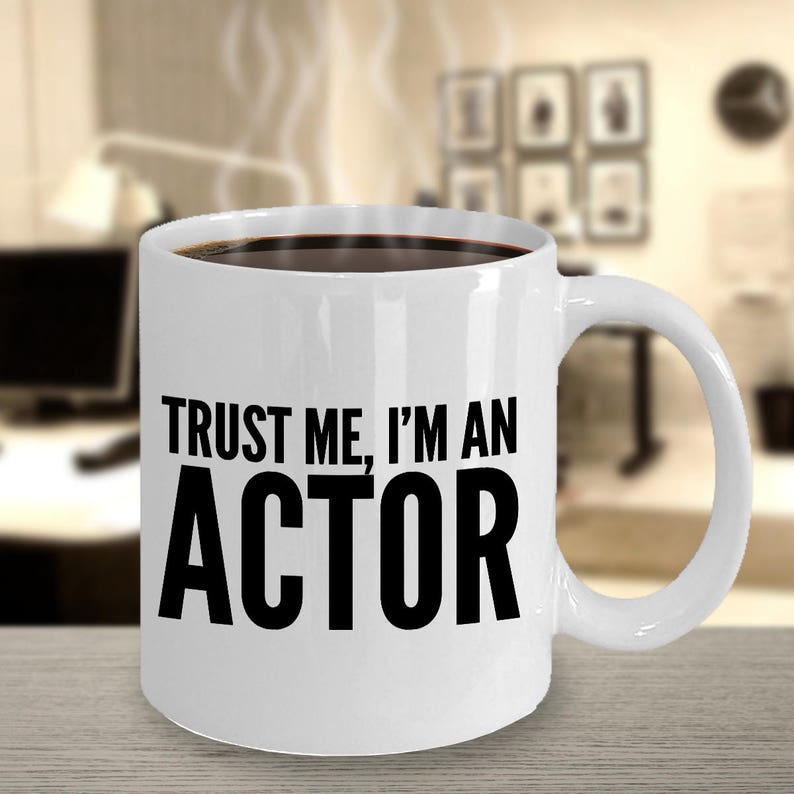 May include: White ceramic coffee mug with black text that reads "Trust me, I'm an actor".