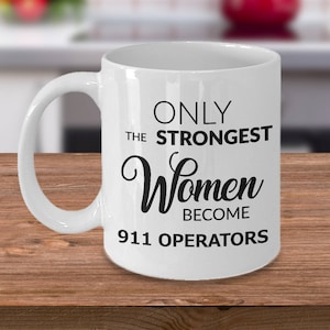 May include: White ceramic coffee mug with black text that reads "Only the strongest women become 911 operators".