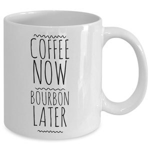 K&ouml;nnte beinhalten: Wei&szlig;e Keramik-Kaffeetasse mit schwarzem Text, der "Coffee Now Bourbon Later" lautet.