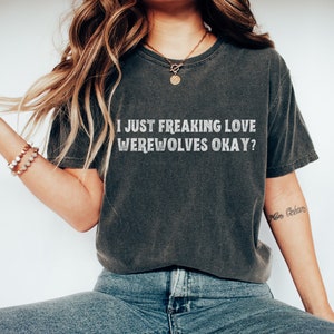 May include: A dark gray t-shirt with the text "I JUST FREAKING LOVE WEREWOLVES OKAY?" printed in white.