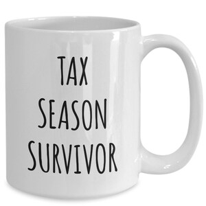 Puede incluir: Taza de caf&eacute; de cer&aacute;mica blanca con texto negro que dice "Tax Season Survivor".