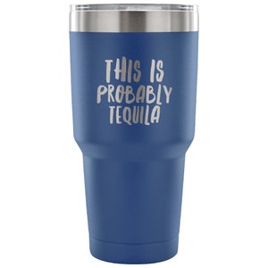 May include: A blue stainless steel tumbler with a white inscription that reads "This is probably tequila".
