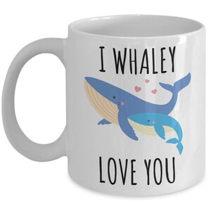 May include: White ceramic coffee mug with a blue whale and a baby whale illustration. The text on the mug reads "I whaley love you".