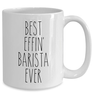 Puede incluir: Taza de café de cerámica blanca con texto negro que dice "Best Effin' Barista Ever".