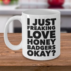 May include: White ceramic coffee mug with black text that reads "I just freaking love honey badgers okay?"
