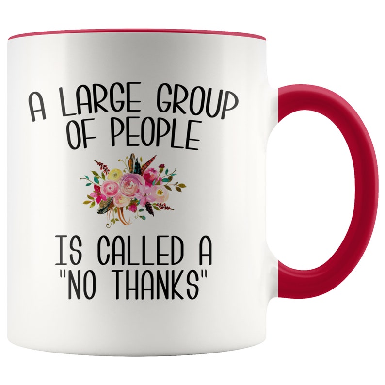 May include: White ceramic coffee mug with a red rim and handle. The mug features a black and white graphic that reads "A large group of people is called a "no thanks"".  The graphic is surrounded by a floral design.