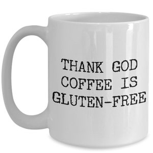 Puede incluir: Taza de caf&eacute; de cer&aacute;mica blanca con texto negro que dice "THANK GOD COFFEE IS GLUTEN-FREE".