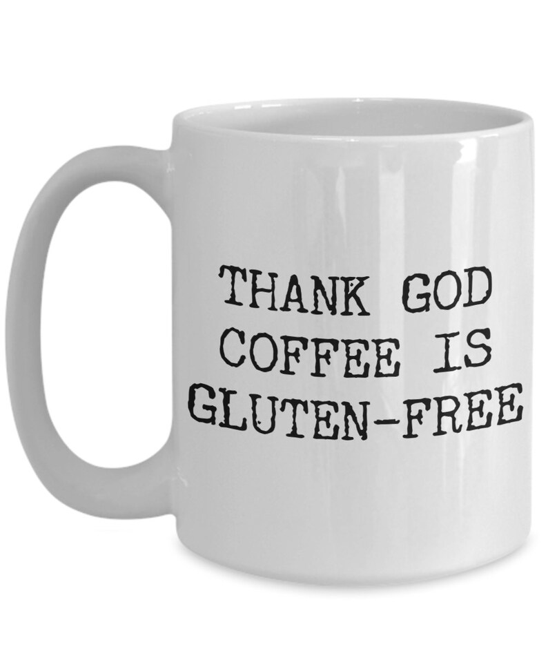 Puede incluir: Taza de caf&eacute; de cer&aacute;mica blanca con texto negro que dice "THANK GOD COFFEE IS GLUTEN-FREE".