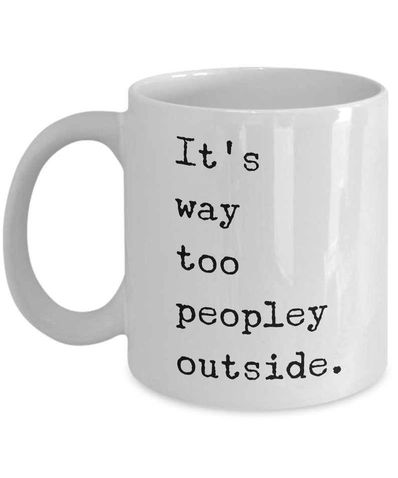 May include: White ceramic coffee mug with black text that reads "It's way too peopley outside."