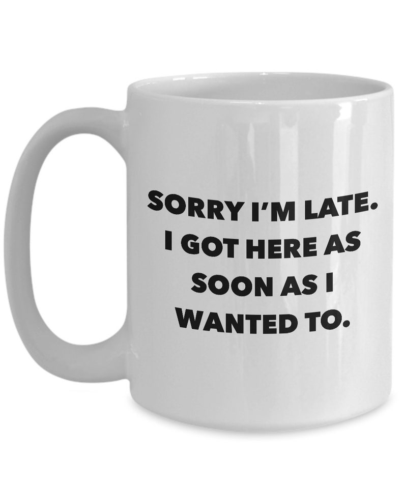 May include: White ceramic coffee mug with black text that reads "Sorry I'm late. I got here as soon as I wanted to."