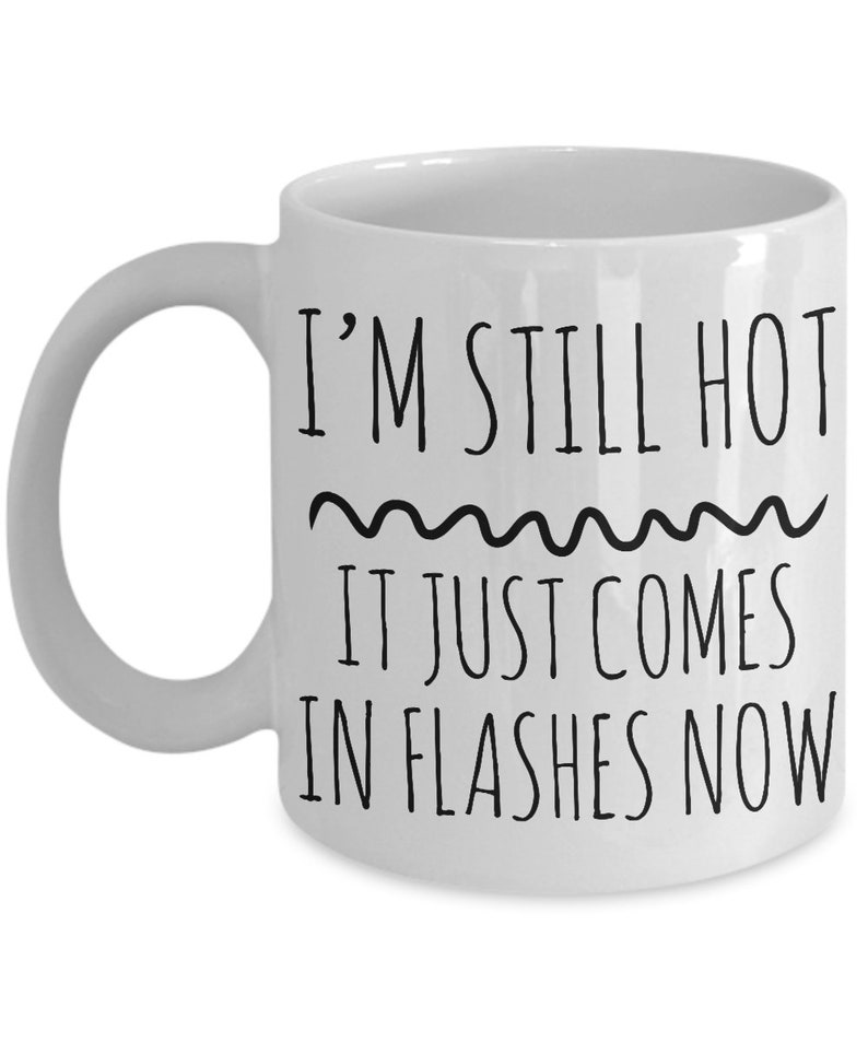 Puede incluir: Taza de caf&eacute; de cer&aacute;mica blanca con texto negro que dice "I'm still hot it just comes in flashes now".
