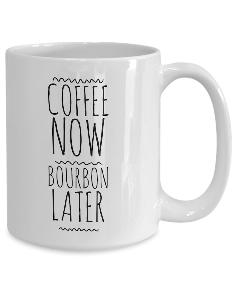 K&ouml;nnte beinhalten: Wei&szlig;e Keramik-Kaffeetasse mit schwarzem Text, der "Coffee Now Bourbon Later" lautet.