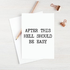 May include: A white card with the text "AFTER THIS HELL SHOULD BE EASY" printed in black typewriter font.