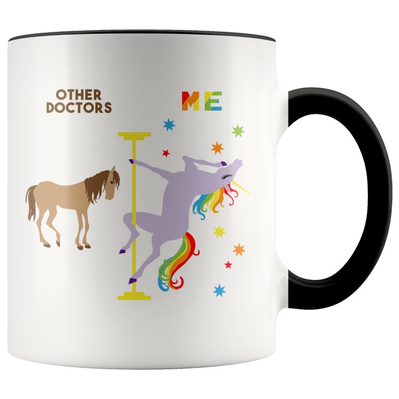 May include: White ceramic coffee mug with a black rim and handle. The mug features a graphic of a unicorn with a rainbow tail, dancing on a pole. The text "Other Doctors" is on the left side of the mug and "ME" is on the right side.