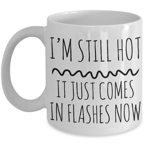 Puede incluir: Taza de caf&eacute; de cer&aacute;mica blanca con texto negro que dice "I'm still hot it just comes in flashes now".