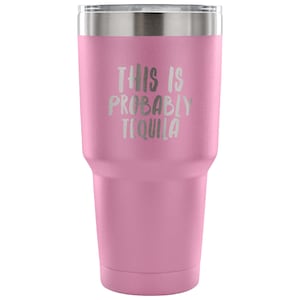 May include: Pink stainless steel tumbler with a white inscription that reads "This is probably tequila".